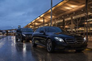 Black Pro Limo Mercedes-Benz sedan and executive van at Melbourne Airport at blue hour