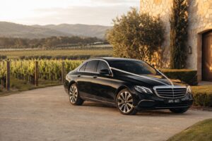 Black Pro Limo Mercedes-Benz wedding car with ivory ribbon at a Yarra Valley vineyard